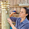 securing a hook to an antique column with a hand-held screwdriver