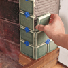 photo of tile being set around the corner of a fireplace leg