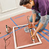 Using a caulk gun, apply panel adhesive to the four sides of the frame