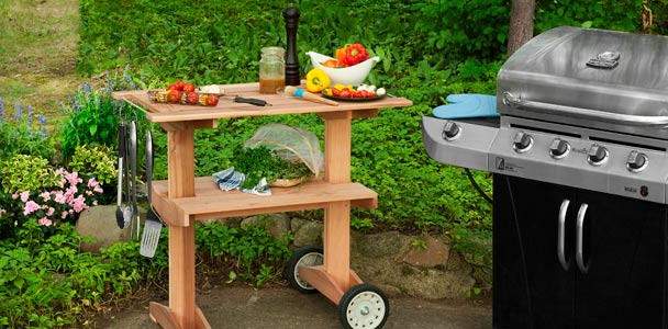 outdoor rolling grill table with grill nearby on patio