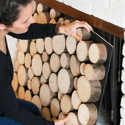 reader installing stacked log imitation summer front for fireplace