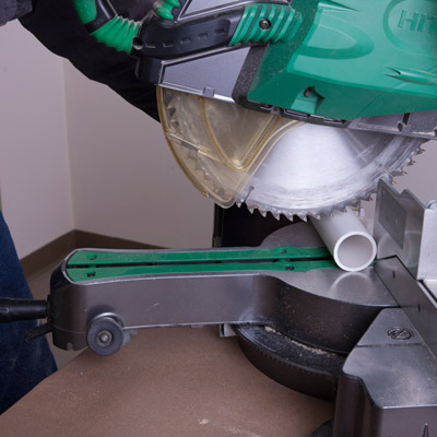 cut PVC pipe for legs with handsaw for giant yard halloween spider