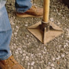 using a hand tamper to compress