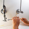 man inserting tube spring in water supply
