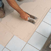 spreading adhesive to install tiles