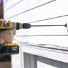 boring a hole through a garage wall to install a floodlight