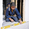 Tom Silva taking measurements while installing a prehung door