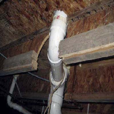 floor joists cut away for plumbing drains
