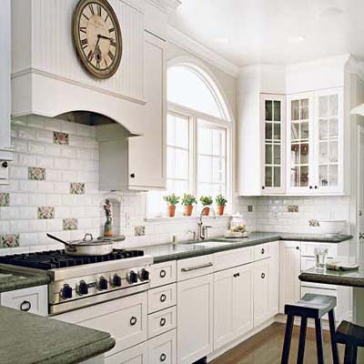 A kitchen with white painted glass front cabinets, beadboard accents and white light fixture  give a vintage look